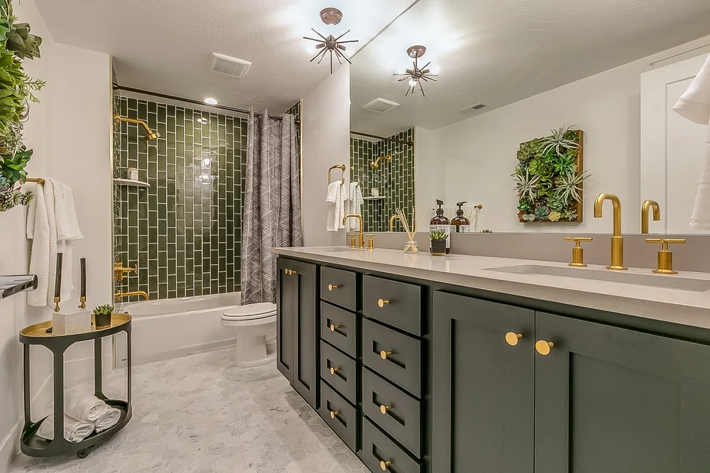 Bathroom renovation with green tile and gold fixtures